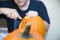 Older man carves a Halloween pumpkin outdoors Royalty Free Stock Photo