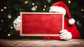 An older man in Christmas costume holding blank wooden board for text, Christmas promo