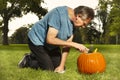 Aging man in city park working on helloween pumpkin Royalty Free Stock Photo