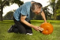 Aging man in city park working on helloween pumpkin Royalty Free Stock Photo