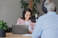 older man and female presenter in a recording studio create a podcast. senior, woman radio presenter or interviewer Royalty Free Stock Photo