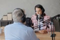 older man and female presenter in a recording studio create a podcast. senior, woman radio presenter or interviewer Royalty Free Stock Photo