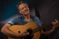 Older Man having fun playing his acoustic guitar Royalty Free Stock Photo