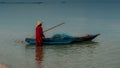 Older man holding onto a smal boat in calm seas on the Gulf of Thailand