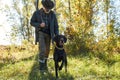 Mature hunter holding dog in forest Royalty Free Stock Photo