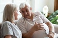 Older man involved in conversation with smiling mature wife.