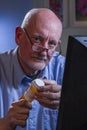 Older man look at camera and refilling prescription online, vertical