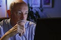 Older man looks serious as he reads off computer, horizontal Royalty Free Stock Photo