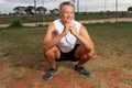 Senior Man at the Park exercising doing deep squats Royalty Free Stock Photo