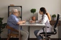 Older man patient meeting woman attending physician for medical checkup Royalty Free Stock Photo