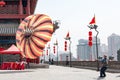 Xian, Senior tries to bring a very large kite into the air on the red lantern-lined wall of Kite flying on wall of Xian, China