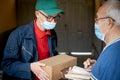 The older man receives a package from the postman Royalty Free Stock Photo