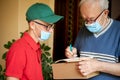 The older man receives a package from the postman Royalty Free Stock Photo