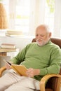 Older man relaxing at home, reading book Royalty Free Stock Photo