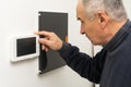 Older man repairing intercom system Royalty Free Stock Photo