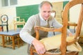 Older man restoring chair in workshop