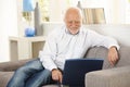 Older man smiling at computer screen at home Royalty Free Stock Photo