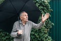 Older man with an umbrella under a stormy sky. An old man with a mustache hides from the rain under an umbrella Royalty Free Stock Photo