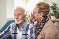 Older man and woman or pensioners with a hearing problem