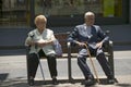 Older man and women with canes sit on bench near La Rambla, Barcelona, Spain