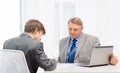 Older man and young man signing papers in office Royalty Free Stock Photo