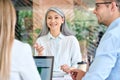 Older mature Asian manager talking to group of younger colleagues interns.