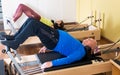 Older man doing exercises of remedial gymnastic on Pilates reformer