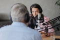 older man and female presenter in a recording studio create a podcast. senior, woman radio presenter or interviewer Royalty Free Stock Photo