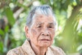 Older people for insurance concept : Portrait of Asian elder woman sitting alone with her black tooth at outdoor in sunny day