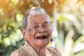 Older people for insurance concept : Portrait of Asian elder woman is smiling with her black tooth with happy at outdoor in sunny