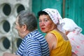 Older people: three Russian pensioners on a bench near the entrance of an apartment building