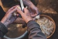 Older person`s hands peeling potatoes