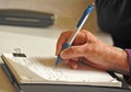 Older persons hand close up writing notes with ballpoint pen.