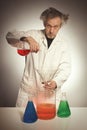 Older retro style chemist working with several dozes of chemicals