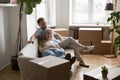 Older senior couple of new landlords, homeowners resting on sofa