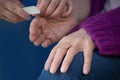 Older senior woman with arthritic hands receiving home spa treatment manicure