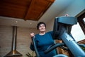 An older senior woman with black short hair is at home exercising on a training machine Royalty Free Stock Photo