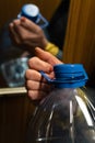 Older senior woman`s hand holding a big blue plastic bottle in an elevator Royalty Free Stock Photo