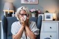 Older senior woman wrapped in a blanket wipes her nose with paper tissues, got sick because she didn't have money to pay for
