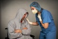 Older sick man being cared for by a young nurse