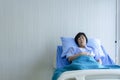 Older sick woman patient lay on bed in hospital with intravenous