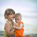 Older sister holds a beautiful girl with Down syndrome