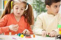 older sister with younger brother made with clay figures, playing together