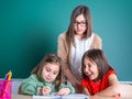 Older sisters looks at her younger sister as she draws in a notebook