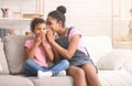 Older and small sisters talking at home at home about secrets Royalty Free Stock Photo