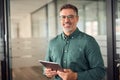 Older smiling businessman holding tablet standing in office. Portrait. Royalty Free Stock Photo