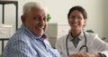 Older smiling clinic male patient and doctor on background