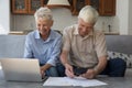 Older spouses managing finances, using laptop, paying bills through e-bank