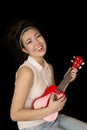 Older teen girl playing ukulele sitting and smiling Royalty Free Stock Photo