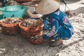 older vietnamese women with traditional hats clean scallops. fishing boats on sea near fishing village close to city Mui Ne, South